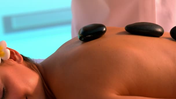 Massaggiatrice collocare pietre calde sulla schiena bruna — Video Stock