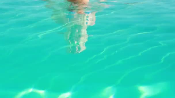 Blonde in blauwe bikini ontspannen in zwembad glimlachen op camera — Stockvideo