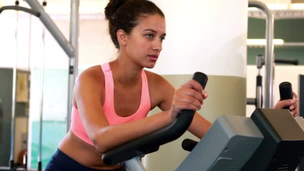 Fit brunette working out on the exercise bike — Stock Video