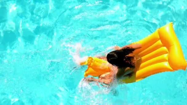 布鲁内特溅上 lilo 在游泳池里 — 图库视频影像