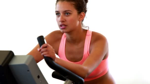 Fit brunette working out on the exercise bike — Stock Video