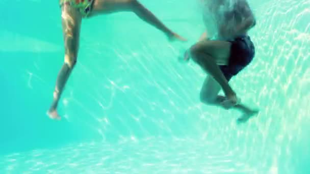 Pareja feliz saltando en la piscina — Vídeo de stock