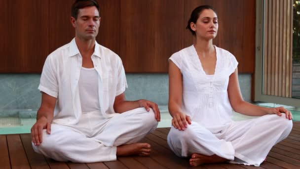 Calm couple in white sitting in lotus pose — Stock Video