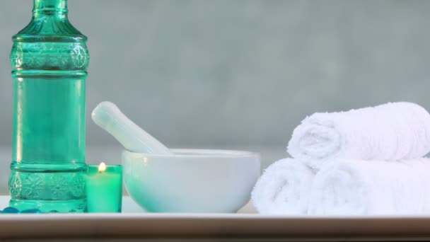 Towels and glass bottle with candle and mortar and pestle — Stock Video