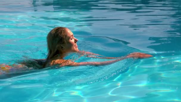 Sexy blonde nager à travers la piscine — Video