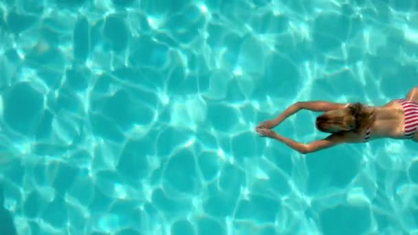 Woman swimming in the pool underwater overhead — Stock Video
