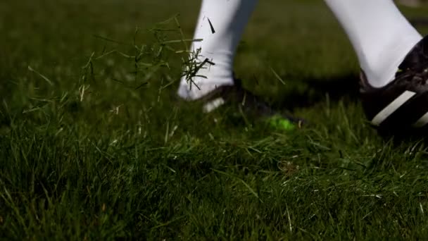 Футболіст штовхає м'яч на траву — стокове відео