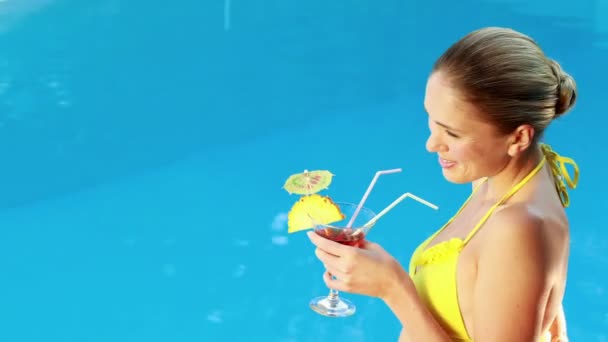 Gorgeous blonde in bikini enjoying a cocktail poolside — Stock Video