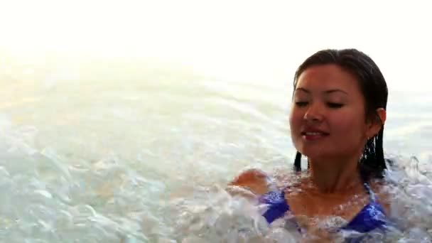 Счастливая брюнетка расслабляется в джакузи — стоковое видео