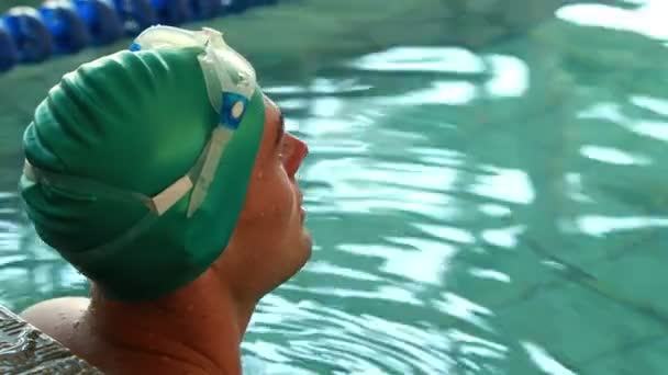 Ajuste nadador sonriendo a la cámara en la piscina — Vídeos de Stock