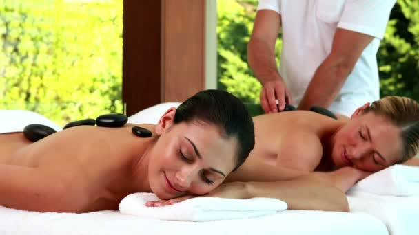 Relaxed friends enjoying hot stone massages — Stock Video