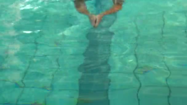Фигурист плавал, улыбаясь камере в бассейне — стоковое видео