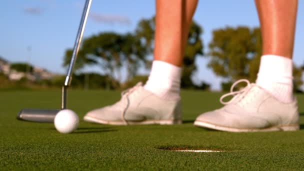 Golferin legt Golfball auf das Grün — Stockvideo