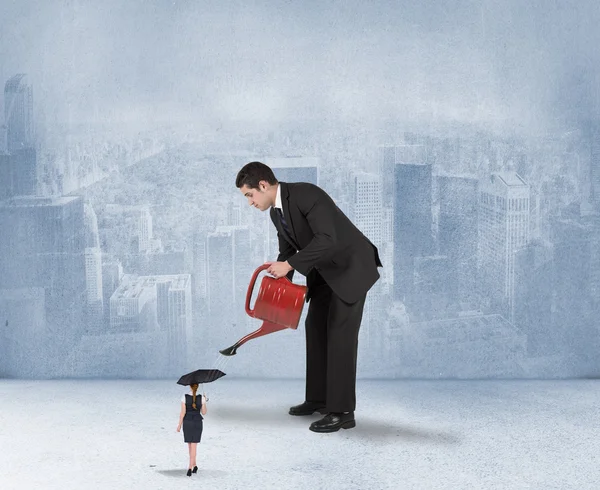 Businessman watering tiny businesswoman — Stock Photo, Image