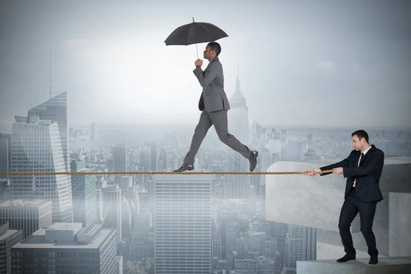 Young business man pulling a tightrope for businessman — Stock Photo, Image