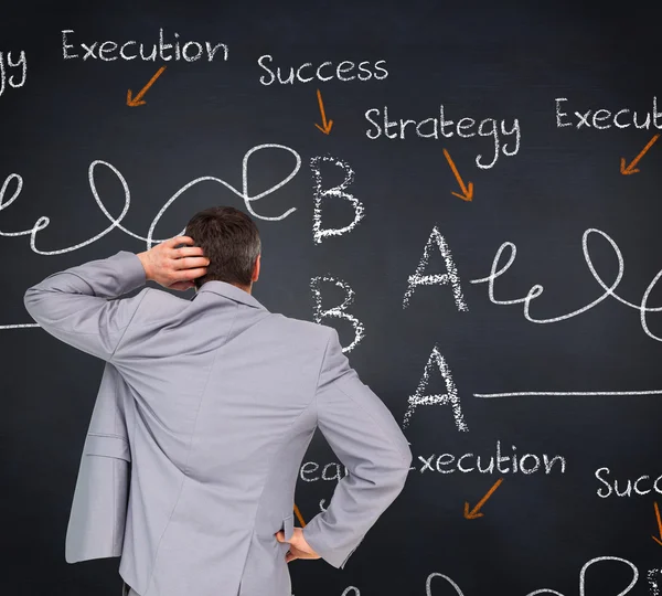 Businessman against blackboard — Stock Photo, Image