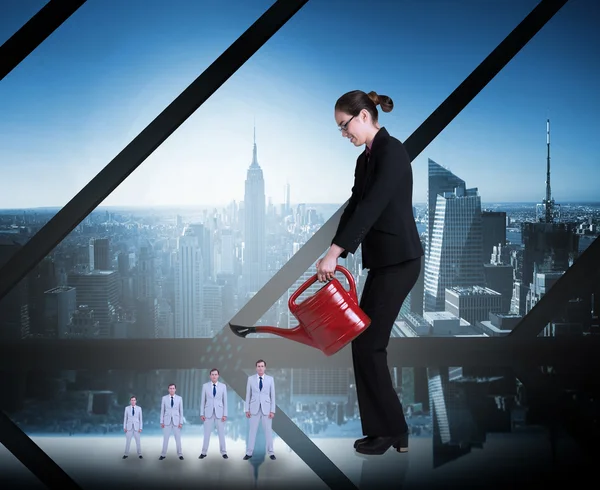 Businesswoman watering tiny business team — Stock Photo, Image