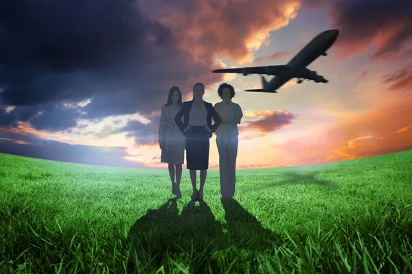 Businesswomen looking at camera with airplane — Stock Photo, Image