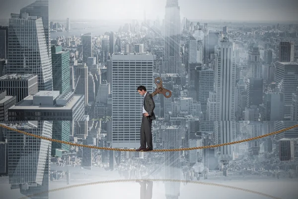 Businessman with hands on hips on tightrope — Stock Photo, Image