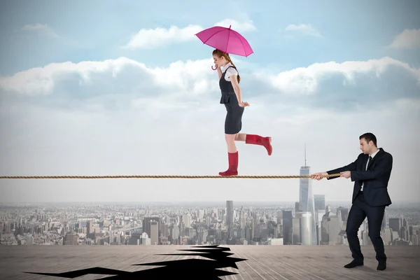 Young business man pulling a tightrope for businesswoman — Stock Photo, Image