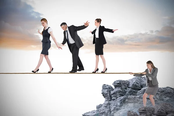 Young businesswoman pulling a tightrope for business people — Stock Photo, Image