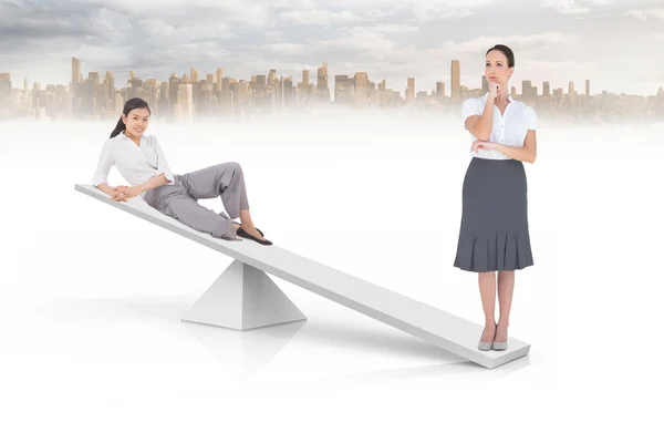 Balanças brancas pesando duas mulheres de negócios — Fotografia de Stock