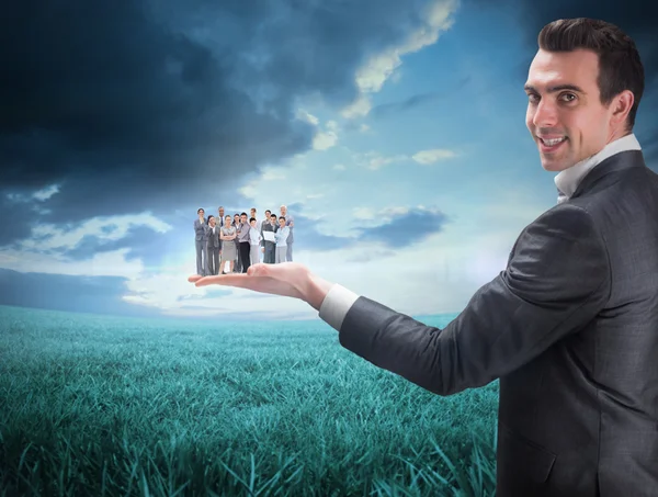 Composite image of businessman holding business team — Stock Photo, Image