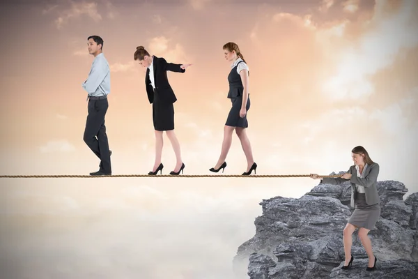 Young businesswoman pulling a tightrope for business people — Stock Photo, Image