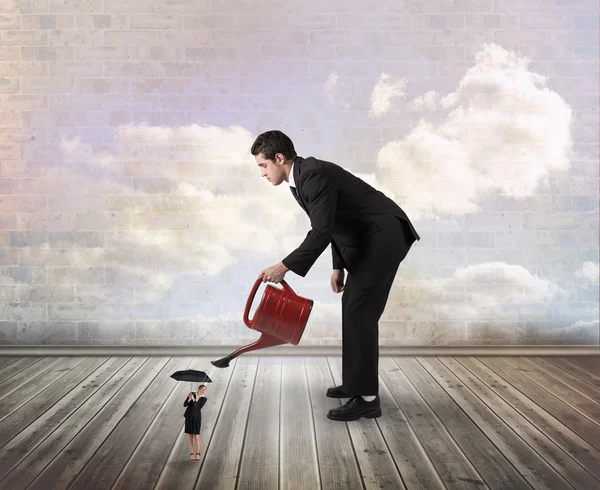 Businessman watering tiny businesswoman — Stock Photo, Image