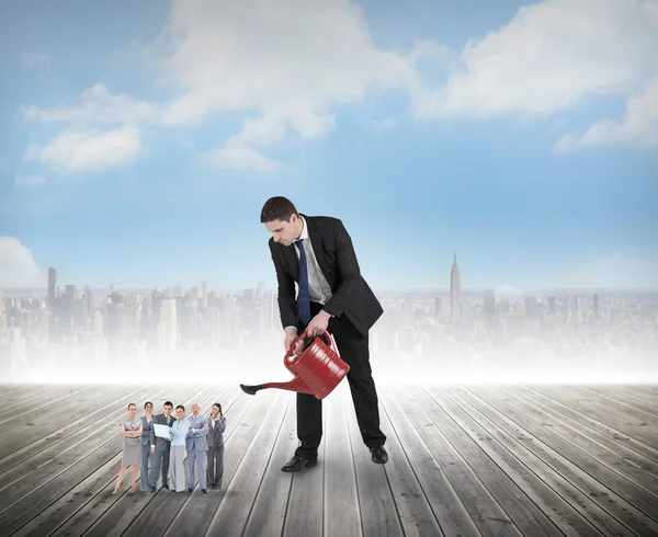 Businessman watering tiny business team — Stock Photo, Image