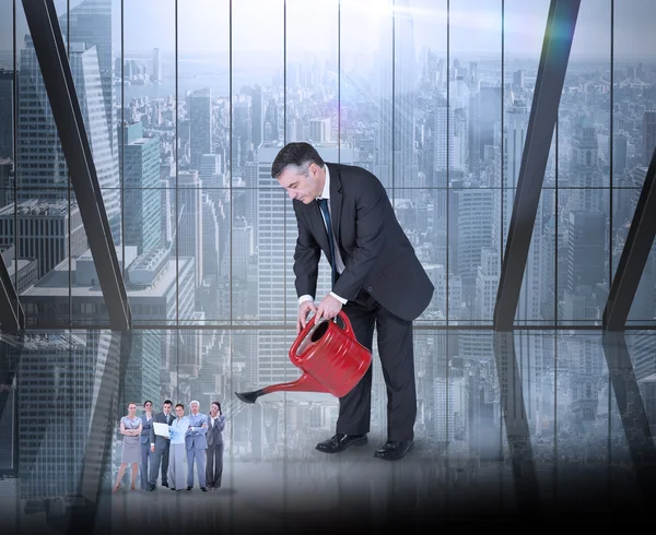 Businessman watering tiny business team — Stock Photo, Image