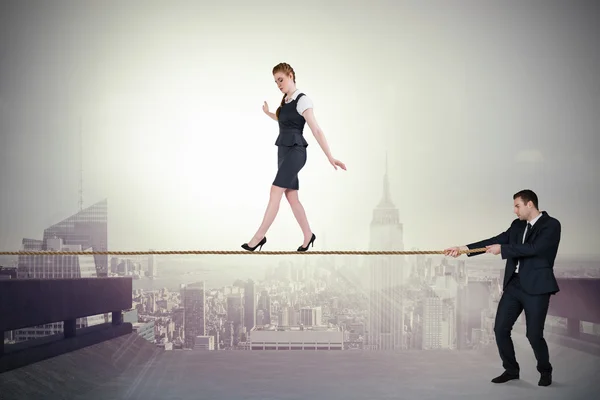 Young business man pulling a tightrope for businesswoman — Stock Photo, Image