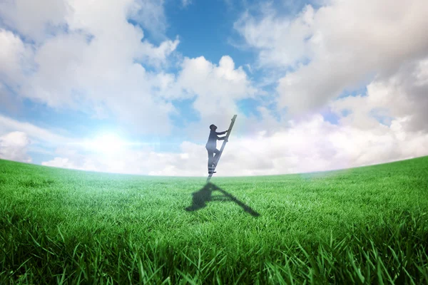 Businessman climbing up ladder against field — Stock Photo, Image