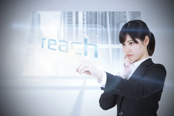 Businesswoman pointing to word reach — Stock Photo, Image