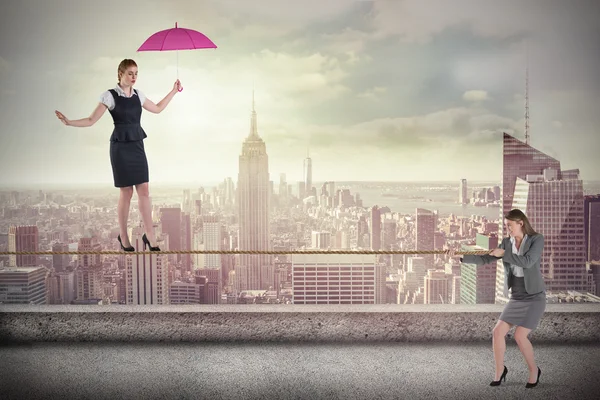 Young businesswoman pulling a tightrope for business woman — Stock Photo, Image