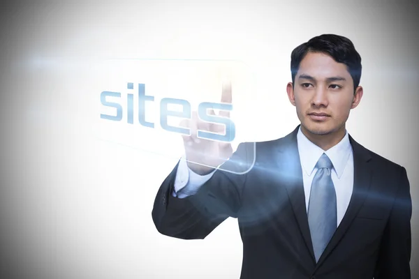 Businessman pointing to word sites — Stok fotoğraf