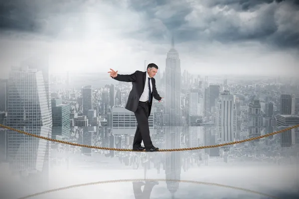 Empresario haciendo acto de equilibrio en la cuerda floja — Foto de Stock