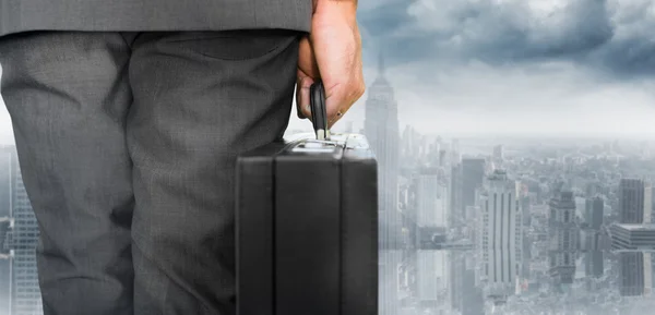 Businessman holding briefcase looking on city — Stock Photo, Image