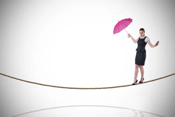 Geschäftsfrau hält Schirm auf Drahtseilakt — Stockfoto