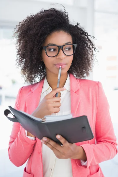 Casual businesswoman looking in her diary — Stock Photo, Image