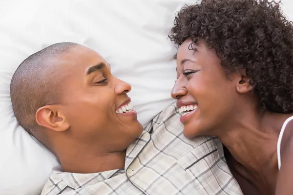 Pareja feliz acostada en la cama juntos —  Fotos de Stock