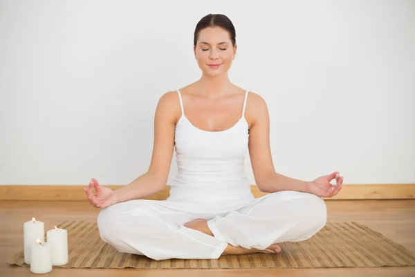 Smiling brunette sitting in lotus pose looking at camera — Stock Photo, Image