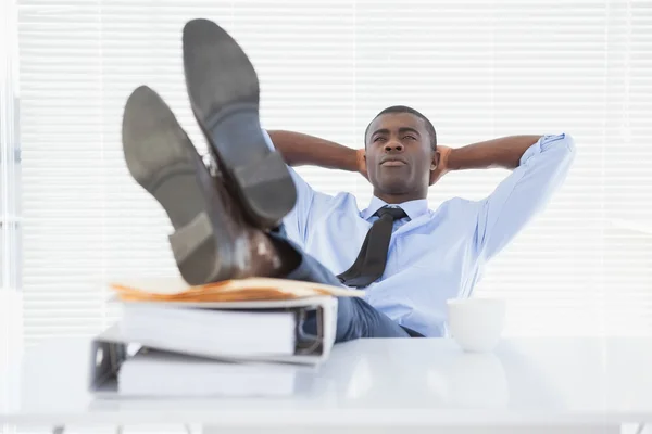 Hombre de negocios relajado sentado en su silla con los pies en alto — Foto de Stock