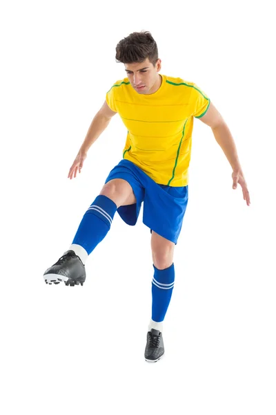 Football player in yellow kicking — Stock Photo, Image