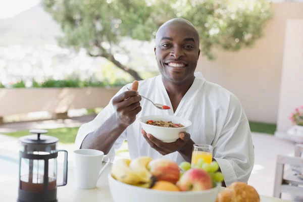 Handsome man in bathrobe having breakfast outside — Stock Photo, Image