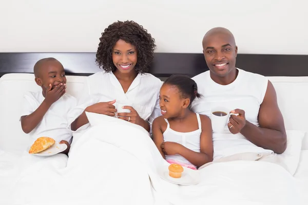 Família feliz tomando café da manhã na cama — Fotografia de Stock