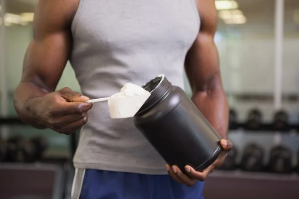 Οικοδόμος σώμα, κρατώντας ένα scoop πρωτεΐνης αναμειγνύεται στο γυμναστήριο — Φωτογραφία Αρχείου