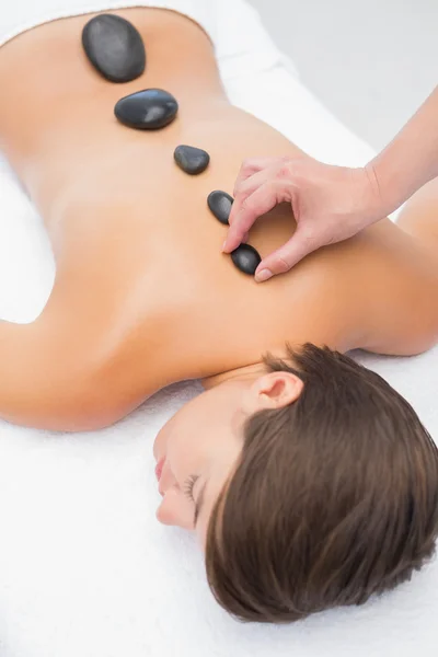 Schöne Frau erhält Steinmassage im Wellness-Center — Stockfoto