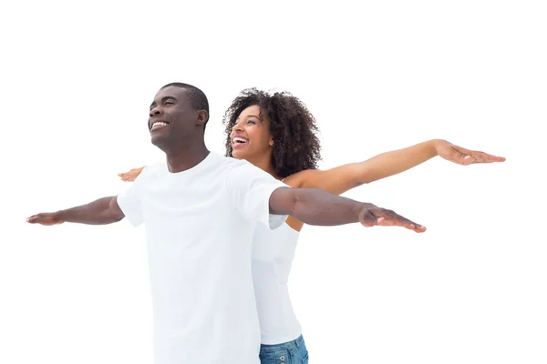 Casual couple standing with arms outstretched — Stock Photo, Image
