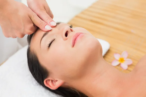 Morena sorridente desfrutando de uma massagem na cabeça — Fotografia de Stock